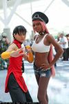  2girls asian black_hair chinese_clothes cosplay crop_top dark_skin hands_on_hips midriff multiple_girls navel non-asian photo pink_hair poison_(final_fight) poison_(final_fight)_(cosplay) short_shorts shorts street_fighter 