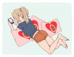  1girl alternate_hairstyle aqua_background barefoot blonde_hair blue_shirt casual cellphone from_behind girls_und_panzer holding kay_(girls_und_panzer) long_hair lying on_stomach orange_shorts phone pillow ponytail scrunchie shirt short_shorts short_sleeves shorts simple_background smartphone solo torinone yes-no_pillow 