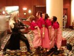 1boy 4girls aerith_gainsborough bag brown_hair closed_eyes cosplay dress final_fantasy final_fantasy_vii impaled indoors lineup long_dress long_hair multiple_girls photo pillar pink_dress sephiroth smile stabbed stabbing standing sword weapon