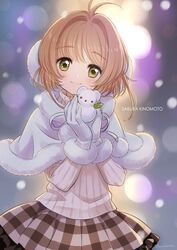  1girl 2016 ahoge backlighting bangs blonde_hair blurry blush bokeh cape card_captor_sakura character_name closed_mouth cowboy_shot dated depth_of_field earmuffs eyebrows_visible_through_hair frilled_skirt frills fur-trimmed_cape fur-trimmed_gloves gloves green_eyes hands_together holding kinomoto_sakura long_sleeves looking_at_viewer morikura_en outdoors plaid plaid_skirt pleated_skirt ribbed_sweater short_hair skirt smile snowing snowman solo standing sweater twitter_username white_cape white_gloves winter 