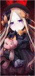  1girl abigail_williams_(fate/grand_order) bangs black_bow black_dress black_hat blonde_hair blush bow closed_mouth dress fate/grand_order fate_(series) forehead hair_bow hat head_tilt highres long_sleeves looking_at_viewer object_hug orange_bow parted_bangs polka_dot polka_dot_bow red_sun sleeves_past_wrists solo stuffed_animal stuffed_toy teddy_bear violet_eyes 
