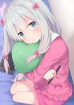  1girl absurdres bare_legs blue_eyes blurry blush bow commentary_request cushion depth_of_field drawing_tablet eromanga_sensei eyebrows_visible_through_hair full_body go-1 hair_between_eyes hair_bow head_tilt highres indoors izumi_sagiri long_hair looking_at_viewer object_hug pajamas pink_bow pout silver_hair sitting stylus 