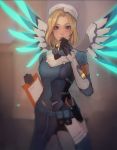  1girl alternate_costume alternate_hairstyle armband artist_name backlighting black_gloves blonde_hair blue_bodysuit blue_eyes blue_wings blurry blurry_background blush bodysuit breasts combat_medic_ziegler cowboy_shot gloves glowing glowing_wings hand_to_own_mouth hat heart holding indoors long_sleeves looking_at_viewer making_of matilda_vin mechanical_wings medium_breasts mercy_(overwatch) overwatch pliers pouch short_hair signature smile solo spread_wings wings yellow_wings 