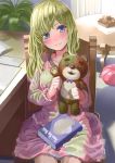  1girl bangs blonde_hair blush book book_on_lap chair closed_mouth coffee_table desk dress green_eyes holding holding_stuffed_animal indoors legs_together light_smile long_hair looking_at_viewer original pink_dress plant potted_plant sitting smile solo stuffed_animal stuffed_toy table teddy_bear yoropa 