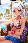  1girl altera_(fate) bikini_top blurry breasts cutoffs dark_skin day depth_of_field drink eyebrows_visible_through_hair fate/grand_order fate_(series) flower_bracelet gendo0032 nail_polish navel outdoors red_eyes short_shorts shorts silver_hair sitting small_breasts smile solo sweat tattoo tied_hair 
