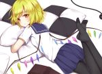  1girl :/ black_legwear blonde_hair blue_skirt checkered_pillow eyebrows_visible_through_hair feet_up flan_(seeyouflan) flandre_scarlet legs_crossed looking_at_viewer looking_back lying no_shoes on_stomach orange_eyes pantyhose pillow pillow_hug pleated_skirt school_uniform serafuku short_hair skirt solo touhou wings 