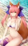  1girl \m/ animal_ears ball bangs barefoot beach beachball bikini blue_bow bow breasts cleavage closed_mouth collarbone day eyebrows_visible_through_hair fate/extra fate_(series) fox_ears fox_tail hair_between_eyes hair_bow highres large_breasts long_hair navel ocean outdoors pink_hair rachione seashell shell side-tie_bikini sidelocks sitting smile solo stomach swimsuit tail tamamo_(fate)_(all) tamamo_no_mae_(fate) twintails wariza white_bikini yellow_eyes 