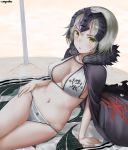  1girl :o arm_support artist_name beach beach_towel bikini blush breasts cape chains cleavage curry_soba fate/apocrypha fate/grand_order fate_(series) fur_trim headphones highres jeanne_alter looking_at_viewer medium_breasts navel reclining ruler_(fate/apocrypha) shadow short_hair signature silver_hair sitting solo swimsuit towel white_bikini yellow_eyes 