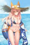  1girl animal_ears bikini blue_bikini breasts cleavage day dhfz181 ears_through_headwear fate/grand_order fate_(series) fox_ears fox_tail hair_ribbon hat highres large_breasts long_hair looking_at_viewer nature navel ocean outdoors pink_hair ribbon solo swimsuit tail tamamo_(fate)_(all) tamamo_no_mae_(swimsuit_lancer)_(fate) v yellow_eyes 