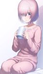  1girl :o alternate_costume bed_sheet blush coffee_cup collarbone commentary cup eyebrows_visible_through_hair eyes_visible_through_hair fate/grand_order fate_(series) hair_over_one_eye highres holding holding_cup long_sleeves open_mouth pajamas pink_hair shadow shielder_(fate/grand_order) short_hair simple_background sitting solo steam tanaka_arumi tareme violet_eyes white_background 