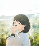  1girl blurry brown_hair clover commentary depth_of_field field flower flower_field four-leaf_clover hand_up highres horizon light_particles looking_at_viewer looking_back nakamura_yukihiro nature original outdoors short_hair sky smile solo sunlight 