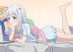  1girl barefoot bedroom blue_eyes blue_shirt bow chin_rest eromanga_sensei eyebrows_visible_through_hair frilled_shirt frills from_side hair_bow highres izumi_sagiri kimu_ryouma long_hair lying multicolored_hair on_stomach pink_bow pink_hair shirt short_sleeves silver_hair smile solo the_pose two-tone_hair 