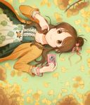  1girl autumn_leaves blush brown_eyes brown_hair camera closed_mouth collarbone eyebrows_visible_through_hair hair_bun holding holding_camera idolmaster idolmaster_cinderella_girls kamille_(vcx68) long_hair long_sleeves looking_at_viewer lying on_back smile solo takamori_aiko 