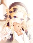  1girl abigail_williams_(fate/grand_order) absurdres bangs black_bow black_dress black_hat blonde_hair blue_eyes blurry blurry_foreground bow covered_mouth depth_of_field dress fate/grand_order fate_(series) hair_bow hat head_tilt highres junpaku_karen long_hair long_sleeves looking_at_viewer noose orange_bow pantyhose parted_bangs polka_dot polka_dot_bow reaching_out sitting solo stuffed_animal stuffed_toy teddy_bear white_legwear 