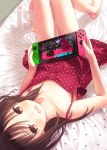  1girl artist_name bangs barefoot bed_sheet blush brown_eyes brown_hair capriccio collarbone commentary dress eyebrows_visible_through_hair handheld_game_console joy-con knees_up legs long_hair looking_at_viewer lying nintendo_switch on_back on_bed open_mouth original playing_games polka_dot polka_dot_dress polka_dot_pillow red_dress smile solo splatoon splatoon_2 tears teeth thighs upside-down 