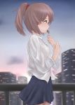  1girl blue_skirt brown_hair building cityscape cowboy_shot expressionless gradient_sky green_eyes highres long_sleeves looking_to_the_side original outdoors ponytail profile railing shirt short_hair skirt skyscraper solo sotiark sunset twilight untucked_shirt white_shirt wind 