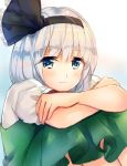  1girl bangs black_bow blue_eyes bow closed_mouth commentary_request crossed_arms eyebrows_visible_through_hair eyelashes green_skirt hair_bow konpaku_youmu looking_at_viewer nagare short_sleeves silver_hair sitting skirt solo touhou 