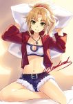  1girl arms_up bandeau bangs bare_legs belt belt_buckle blonde_hair breasts buckle character_name cleavage cleavage_cutout closed_mouth collarbone cutoffs denim denim_shorts eyebrows_visible_through_hair fate/apocrypha fate_(series) green_eyes holding jacket jewelry long_hair long_sleeves looking_at_viewer medium_breasts mordred_(fate) mordred_(fate)_(all) navel necklace open_clothes open_jacket parted_bangs pendant pillow ponytail red_jacket shiny shiny_hair shiny_skin shorts sidelocks sitting smile solo stomach yashiro_seika yokozuwari 
