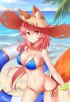  1girl absurdres animal_ears april_cho bikini blue_bikini breasts cleavage day ears_through_headwear fate/extella fate/extra fate/grand_order fate_(series) fox_ears fox_tail groin hat highres innertube large_breasts long_hair looking_at_viewer navel ocean outdoors palm_tree pink_hair side-tie_bikini smile solo straw_hat swimsuit tail tamamo_(fate)_(all) tamamo_no_mae_(swimsuit_lancer)_(fate) tree yellow_eyes 