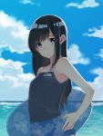  1girl asashio_(kantai_collection) black_hair blue_eyes blue_sky blue_swimsuit blurry clouds competition_school_swimsuit cowboy_shot day depth_of_field highres horizon imai_(tomori_kuro) innertube kantai_collection long_hair looking_at_viewer name_tag ocean outdoors school_swimsuit sky solo swimsuit water 