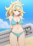  1girl alternate_costume alternate_hairstyle arms_behind_back awkward bare_shoulders beach bikini blonde_hair blue_bikini blue_eyes blue_hairband blue_sky blurry blurry_background blush breasts cleavage clouds collarbone cowboy_shot day enemy_lifebuoy_(kantai_collection) flight_deck floatie gambier_bay_(kantai_collection) gluteal_fold groin hair_between_eyes hairband highres holding kantai_collection kodama_(user_rnfr3534) large_breasts long_hair looking_at_breasts messy_hair navel o-ring o-ring_top outdoors ponytail sand sky solo stomach swimsuit thighs 