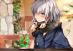  1girl bangs bendy_straw blue_jacket blurry blurry_background blush brown_eyes closed_mouth commentary_request cup depth_of_field drink drinking_glass drinking_straw eyebrows_visible_through_hair fate/grand_order fate_(series) fur-trimmed_jacket fur-trimmed_sleeves fur_trim hair_between_eyes hand_up indoors jacket jeanne_d&#039;arc_(alter)_(fate) jeanne_d&#039;arc_(fate)_(all) long_sleeves looking_at_viewer pon_(ponidrop) silver_hair sleeves_past_wrists solo wicked_dragon_witch_ver._shinjuku_1999 