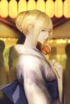  1girl artoria_pendragon_(all) bangs blonde_hair blue_bow bow braid brown_eyes candy_apple character_name closed_mouth commentary_request eyebrows_visible_through_hair fate/stay_night fate_(series) food hair_between_eyes hair_bun hand_up highres holding holding_food japanese_clothes kimono lantern long_sleeves looking_at_viewer looking_to_the_side marumoru obi paper_lantern saber sash sidelocks solo transparent white_kimono wide_sleeves 