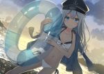  1girl alternate_costume bangs bare_shoulders beach bikini black_hat blue_eyes blush breasts clouds collarbone commentary_request dawn eyebrows_visible_through_hair flat_cap hair_between_eyes hat head_tilt hibiki_(kantai_collection) holding holding_innertube innertube jacket_on_shoulders kantai_collection long_hair looking_at_viewer miko_fly navel ocean outdoors sand side-tie_bikini sidelocks signature silver_hair small_breasts smile solo stomach swimsuit thighs waves 