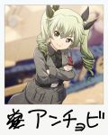  1girl anchovy anzio_military_uniform bangs belt black_belt black_neckwear black_shirt blurry blurry_background closed_mouth commentary_request crossed_arms depth_of_field dress_shirt drill_hair eyebrows_visible_through_hair girls_und_panzer green_hair grey_jacket grey_pants ground_vehicle haniwa_(leaf_garden) highres jacket long_hair long_sleeves looking_at_viewer military military_uniform military_vehicle motor_vehicle necktie pants partial_commentary red_eyes sam_browne_belt shirt smile standing tank twin_drills twintails uniform 