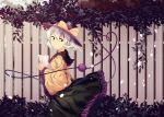  1girl blurry blurry_background bow dress fence furahata_gen green_eyes green_hair hat hat_bow highres holding holding_paper komeiji_koishi leaf light_particles long_sleeves one_eye_closed paper short_hair smile solo third_eye touhou wide_sleeves yellow_bow 