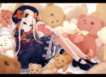  1girl abigail_williams_(fate/grand_order) bangs black_bow black_dress black_footwear black_hat blonde_hair blue_eyes blurry blurry_background bow dress fate/grand_order fate_(series) forehead hair_bow hat leaning_back legs long_hair looking_at_viewer omaru_gyuunyuu orange_bow parted_bangs parted_lips pillow polka_dot polka_dot_bow ribbed_dress sitting sleeves_past_fingers sleeves_past_wrists solo stuffed_animal stuffed_toy teddy_bear white_bloomers 
