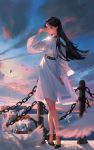  1girl absurdres anklet arm_up belt bird black_hair brown_eyes building chains choker closed_mouth clouds dove dress feathers high_heels highres houses jewelry legs long_hair mountainous_horizon ocean original shi_shihou sky smile standing water white_dress wide_sleeves 
