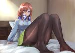  1girl bangs bed bed_sheet blue_cardigan blue_eyes breasts brown_hair collared_shirt commentary_request dress_shirt go-toubun_no_hanayome gomashiwo_o green_skirt hair_between_eyes hair_over_one_eye headphones headphones_around_neck highres indoors large_breasts long_hair looking_at_viewer nakano_miku pantyhose pillow pleated_skirt shirt sitting skirt solo white_shirt 