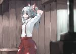  1girl arms_up bangs blurry_foreground bow commentary cowboy_shot eyebrows_visible_through_hair fujiwara_no_mokou hair_bow hair_ornament hair_stick ichiba_youichi indoors long_hair looking_at_viewer mouth_hold ofuda pants ponytail red_eyes red_pants shirt short_sleeves silver_hair solo standing suspenders touhou tying_hair white_bow white_shirt 