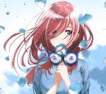  1girl bangs blue_dress blue_eyes blush breasts commentary_request dress flower go-toubun_no_hanayome hair_between_eyes hair_over_eyes hands_clasped headphones headphones_around_neck highres holding holding_flower long_hair looking_at_viewer medium_breasts nakano_miku own_hands_together petals redhead solo taku3949 upper_body 