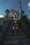  1girl bag black_legwear blew_andwhite blue_sky brown_footwear brown_hair brown_sailor_collar brown_skirt clouds day disconnected_mouth from_below hair_ribbon highres kantai_collection kneehighs lamppost loafers looking_at_viewer outdoors photo_background pole ponytail power_lines ribbon sailor_collar school_bag school_uniform serafuku shikinami_(kantai_collection) shoes short_ponytail skirt sky smile solo stairs 