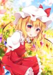  1girl :p arms_behind_back bending_forward blonde_hair blue_sky blurry blush clouds commentary_request cravat crystal day depth_of_field eyebrows_visible_through_hair flandre_scarlet garden hair_between_eyes hat hat_ribbon highres looking_at_viewer miy@ mob_cap outdoors petals puffy_short_sleeves puffy_sleeves red_eyes red_skirt red_vest ribbon shirt short_hair short_sleeves side_ponytail skirt sky solo standing tongue tongue_out touhou vest white_shirt wind wings yellow_neckwear 