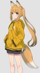  1girl animal_ears blonde_hair commentary english_commentary feet_out_of_frame fox_ears fox_tail green_eyes grey_background hands_in_pockets highres hood hooded_jacket jacket long_hair nemeneko_6 original shorts simple_background smile solo standing tail twintails yellow_jacket 