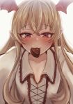 1girl blonde_hair blurry blush chocolate chocolate_heart collarbone commentary_request eyebrows_visible_through_hair granblue_fantasy head_wings heart highres long_hair looking_at_viewer mouth_hold pointy_ears red_eyes shingeki_no_bahamut smile solo upper_body usameruti vampy 