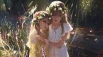  2girls artist_name bangs bare_shoulders blonde_hair blue_eyes bug butterfly closed_mouth day dress flower forest g-tz hair_between_eyes hand_on_another&#039;s_shoulder highres hug insect light_rays lips long_hair looking_at_viewer multiple_girls nature original outdoors parted_lips standing sunbeam sunlight white_dress yellow_dress 