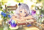  1girl blue_eyes book bug butterfly chair commentary_request flower gilse holding holding_spoon insect long_hair open_book original silver_hair sitting solo spoon 