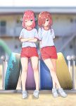  2girls ;( arms_behind_back blue_eyes blurry blurry_background blush closed_mouth commentary_request crossed_arms crossed_legs full_body go-toubun_no_hanayome gym_uniform hair_over_one_eye hair_ribbon highres kongbai looking_at_viewer medium_hair multiple_girls nakano_miku nakano_nino outdoors pink_hair red_shorts ribbon shirt short_sleeves shorts siblings sisters smile standing t-shirt tire v-shaped_eyebrows white_footwear white_shirt 