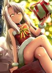  1girl absurdres backlighting bangs bare_shoulders blush borumete bow box breasts chloe_von_einzbern choker christmas crossed_legs dark_skin dress fate/grand_order fate_(series) fur-trimmed_dress gift gift_box hair_ornament hairpin half_updo highres long_hair looking_at_viewer orange_eyes pink_hair red_bow red_dress sidelocks sitting small_breasts solo thighs wrist_cuffs 