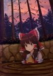  1girl ascot bangs bare_shoulders bare_tree blush bow brown_eyes brown_hair clenched_teeth clouds commentary eyebrows_visible_through_hair falling_leaves frilled_bow frilled_shirt_collar frills hair_bow hair_tubes hakurei_reimu highres kazenokaze leaf outdoors parted_lips partially_submerged red_bow ribbon_trim scared short_hair_with_long_locks sidelocks solo sweat teeth touhou tree twilight upper_body yellow_neckwear 