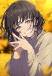  1girl autumn autumn_leaves bangs black_hair blurry blurry_background blurry_foreground blush brown_nails brown_sweater commentary_request depth_of_field earrings eyebrows_behind_hair fingernails fingers_together grey_eyes grin hand_up highres jewelry long_hair long_sleeves looking_at_viewer nail_polish original puffy_long_sleeves puffy_sleeves smile sogawa solo stud_earrings sweater upper_body 