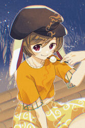  1girl blonde_hair brown_hat closed_mouth commentary_request dango flat_cap floppy_ears food hat highres holding holding_skewer katsuragi_atori looking_at_viewer orange_shirt red_eyes ringo_(touhou) shirt short_sleeves shorts sitting skewer smile solo touhou twitter_username wagashi yellow_shorts 
