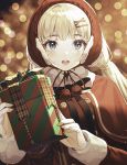  1girl :o bangs black_neckwear black_ribbon blonde_hair blue_eyes blurry blush bokeh box breasts capelet chin_strap christmas depth_of_field earmuffs eyebrows_visible_through_hair fur-trimmed_capelet fur_trim gift gift_box hair_ornament hairclip hat highres holding holding_gift holly kinty light_particles long_hair long_sleeves looking_at_viewer neck_ribbon original plaid pom_pom_(clothes) red_background red_capelet red_headwear red_theme ribbon smile solo upper_body 