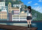  1girl architecture black_hair black_legwear black_skirt building city clouds cloudy_sky commentary_request day from_behind fubuki_(kantai_collection) hand_on_own_face highres house kantai_collection kneehighs medium_hair mountain pier ponytail scenery school_uniform serafuku shirt shoes sidelocks skirt sky solo standing wasabi60 water white_shirt 