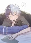  1boy :o animal_ears animal_hands aoyagi_touya black_cat blue_eyes blue_hair book cat cat_ears closed_eyes commentary dark_blue_hair grey_shirt highres holding holding_book jishio lying male_focus mole mole_under_eye multicolored_hair on_stomach open_book open_mouth pillow project_sekai shirt short_hair short_sleeves solo speech_bubble split-color_hair symbol-only_commentary translation_request two-tone_hair white_background 