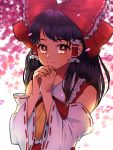  1girl ascot black_hair blurry blurry_background bow cherry_blossoms commentary detached_sleeves eyebrows_visible_through_hair hair_bow hair_tubes hakurei_reimu hands_together highres light_smile looking_at_viewer mito_(mo96g) own_hands_together petals red_bow red_shirt shirt solo touhou upper_body yellow_eyes yellow_neckwear 